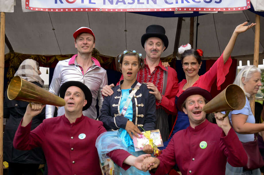 ROTE NASEN Clowns stehen vor dem Zelt des ROTE NASEN Sommercircus