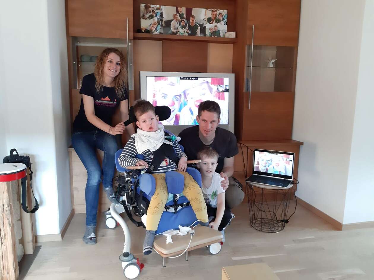 Marius, Linus und CURAplus Team auf einem Foto mit den Clowns im Hintergrund auf dem Fernseher