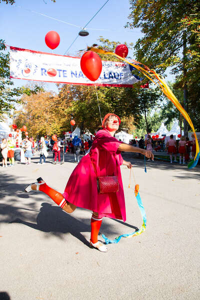 ROTE NASEN Clownin schwingt bunte Bänder beim ROTE NASEN LAUF